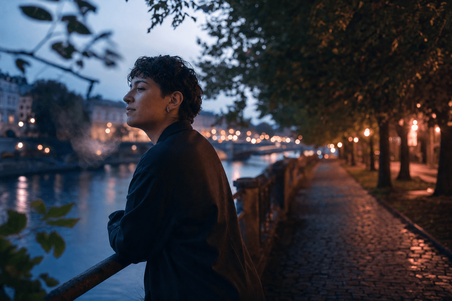 Queere Person hält bei einem ruhigen Abendspaziergang am Fluss inne